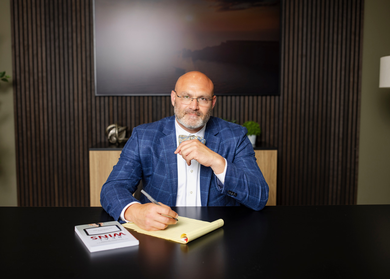 Mitchel Krause at his desk, pen in hand over a legal pad